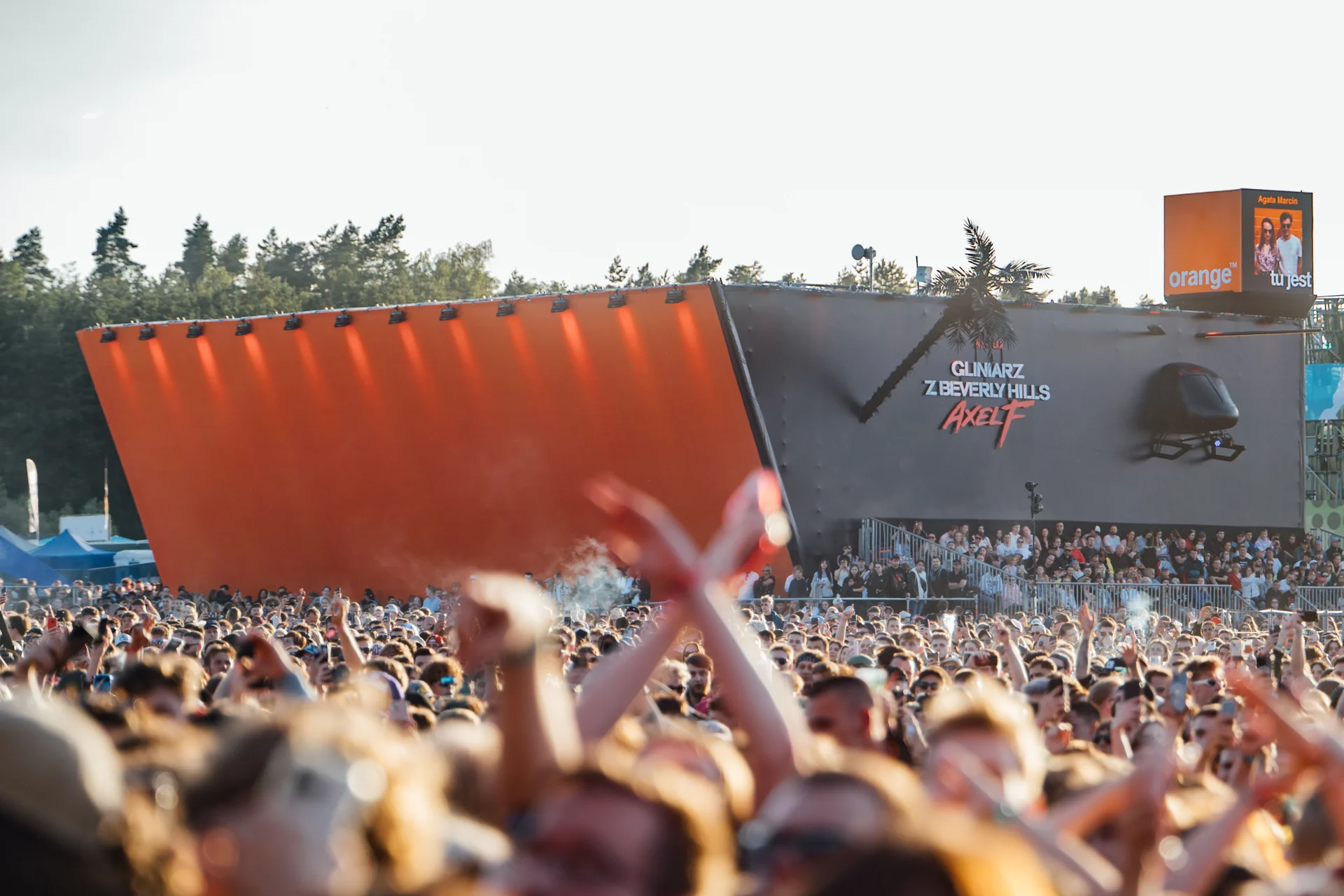 Szeroki plan głównej sceny Opener Festival 2024 z panelami w barwach Orange i dużą publicznością, podkreślający sponsoring.